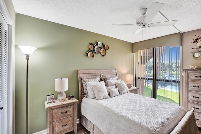 bedroom with access to exterior, a textured ceiling, a closet, and ceiling fan