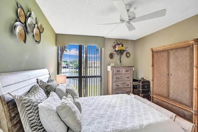 bedroom with access to exterior, ceiling fan, and a textured ceiling