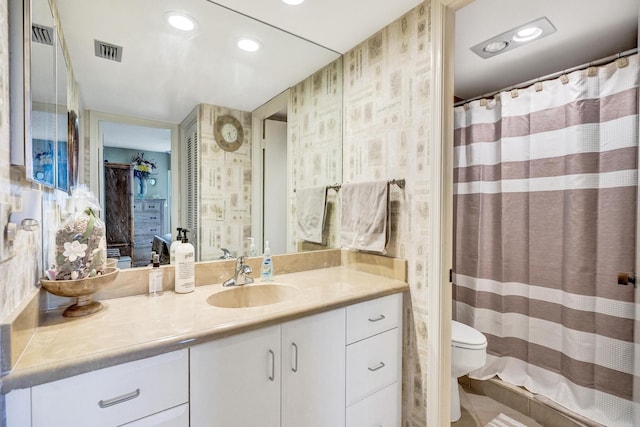 bathroom featuring vanity, toilet, and walk in shower