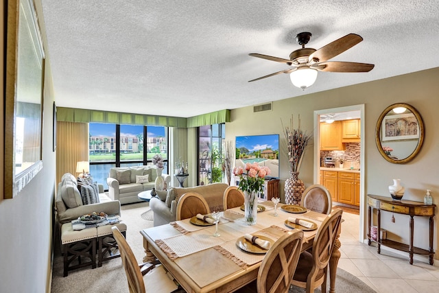 dining area with light tile patterned floors, a textured ceiling, and ceiling fan