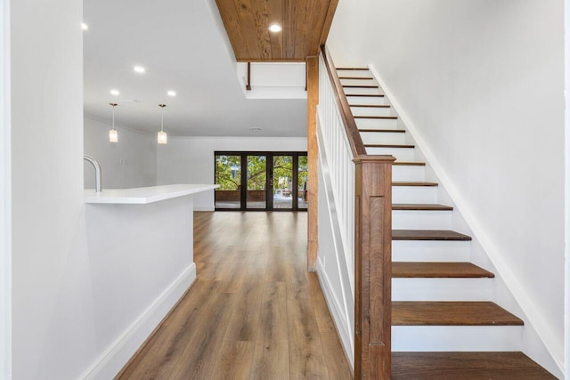 stairs with recessed lighting, baseboards, and wood finished floors