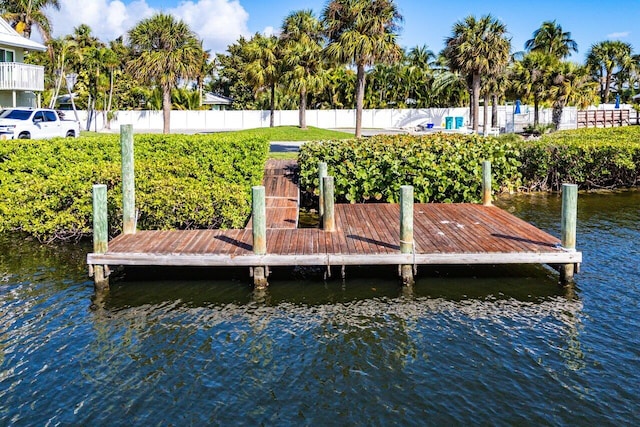 dock area with a water view and fence