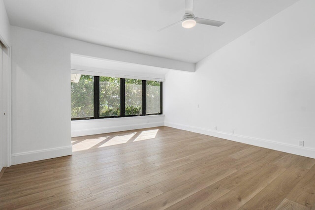 spare room with baseboards and wood finished floors