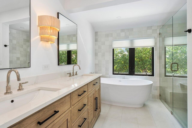 full bathroom featuring a wealth of natural light, a sink, a shower stall, and tile patterned floors