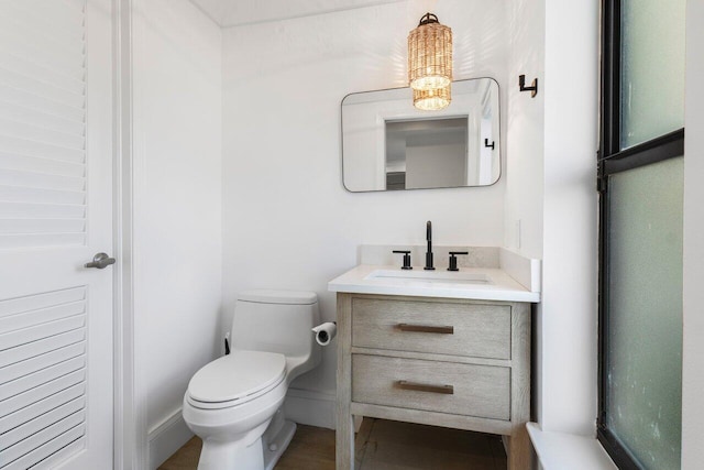 bathroom with vanity, toilet, and baseboards