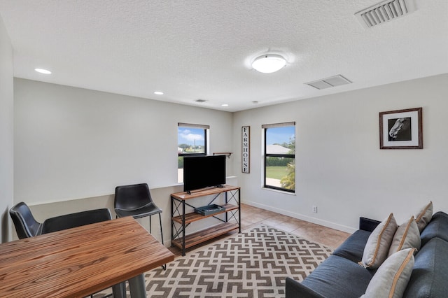 home office with a textured ceiling and light tile patterned flooring