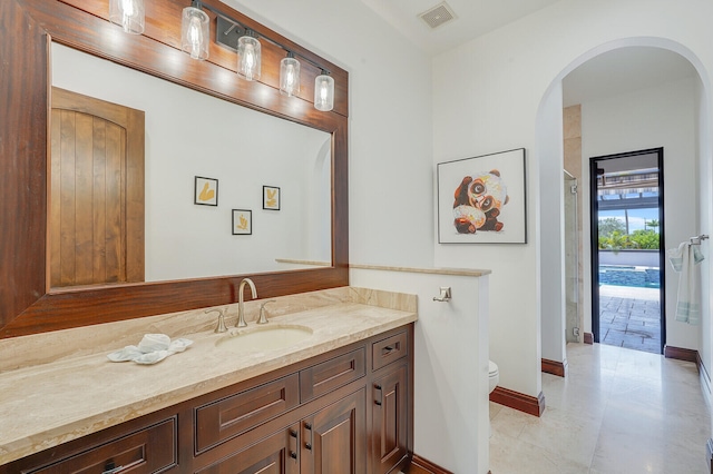 bathroom featuring vanity, toilet, and a shower