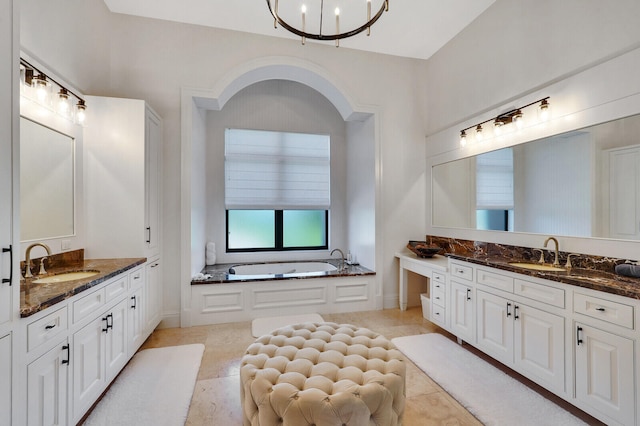 bathroom featuring tile patterned floors, a bathtub, a notable chandelier, and vanity