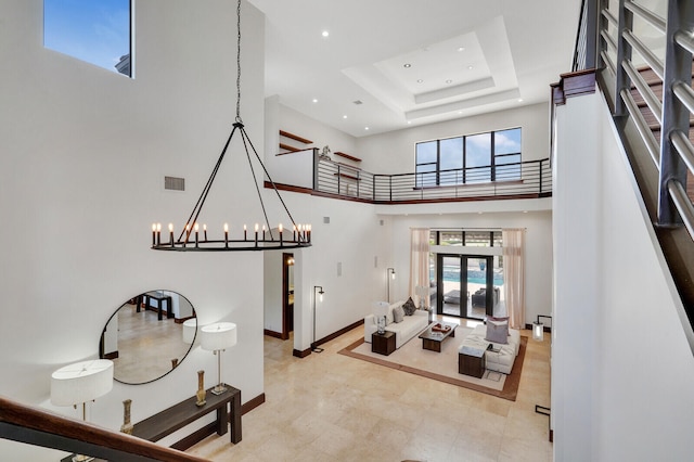 foyer featuring a high ceiling, a chandelier, and a tray ceiling