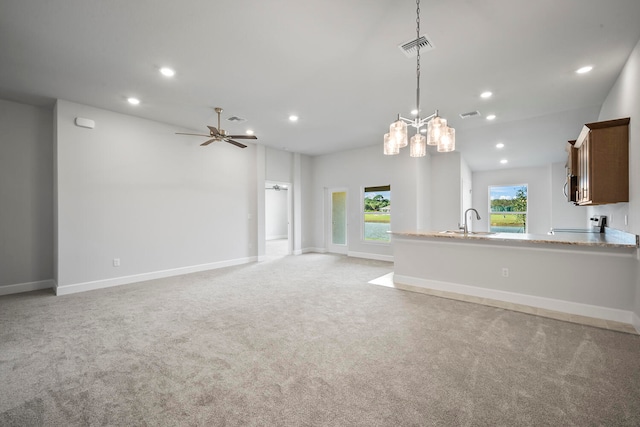 unfurnished living room featuring ceiling fan, sink, and light carpet