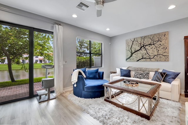 living room featuring ceiling fan and light hardwood / wood-style floors