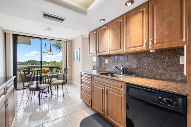 kitchen featuring tasteful backsplash, dark stone countertops, sink, black dishwasher, and light tile patterned floors