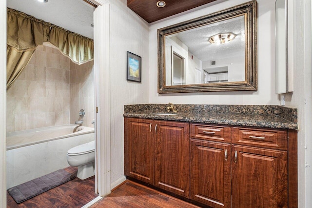 full bathroom with toilet, vanity, hardwood / wood-style floors, tub / shower combination, and a textured ceiling