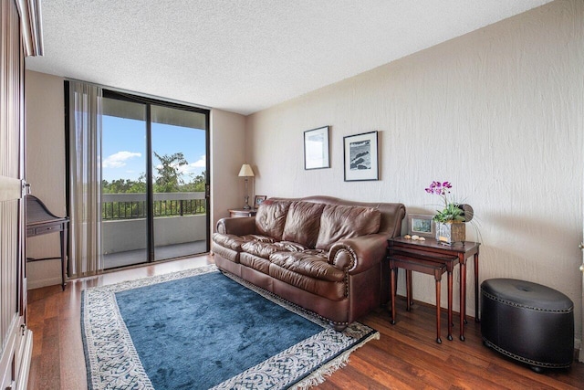 living room featuring a textured ceiling, a wall of windows, and dark hardwood / wood-style flooring