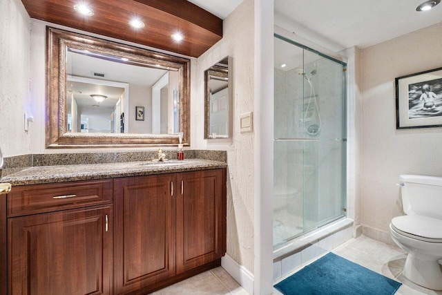 bathroom with a shower with shower door, vanity, tile patterned flooring, and toilet