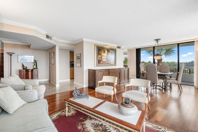 living room featuring a wall of windows, a textured ceiling, and light hardwood / wood-style floors