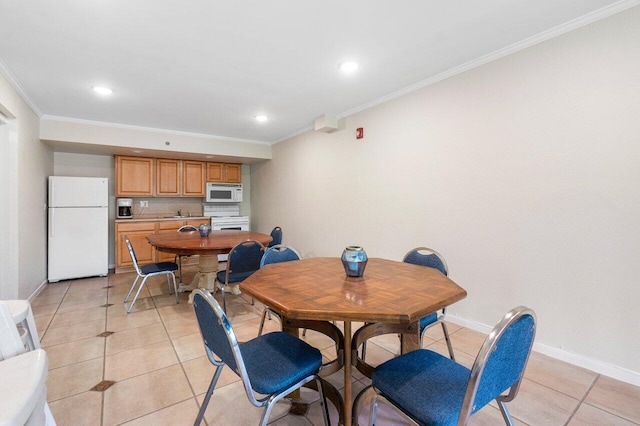 dining space with light tile patterned floors and crown molding