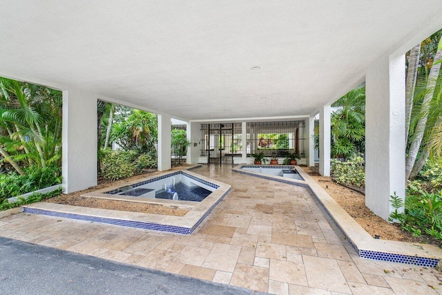 exterior space featuring an in ground hot tub and a patio