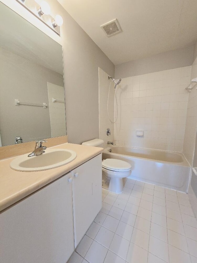 full bathroom with tile patterned flooring, toilet, tiled shower / bath combo, and vanity