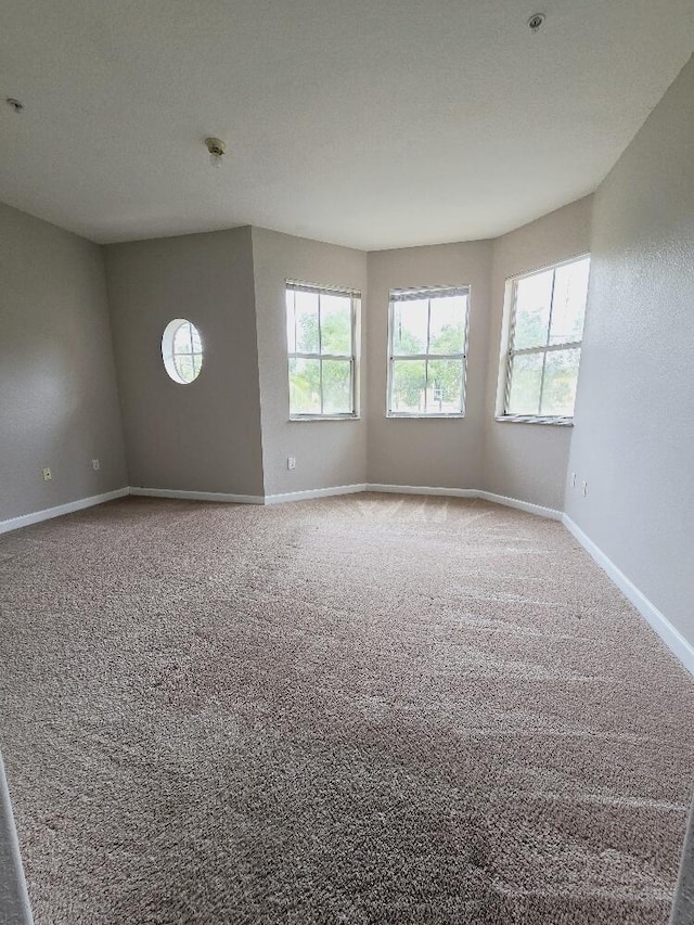 carpeted spare room with baseboards