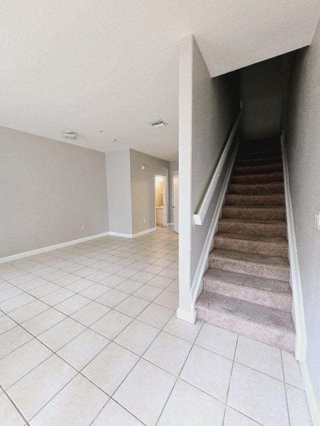 staircase with visible vents, baseboards, and tile patterned floors