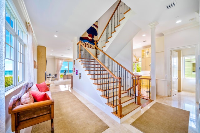 staircase with crown molding and decorative columns