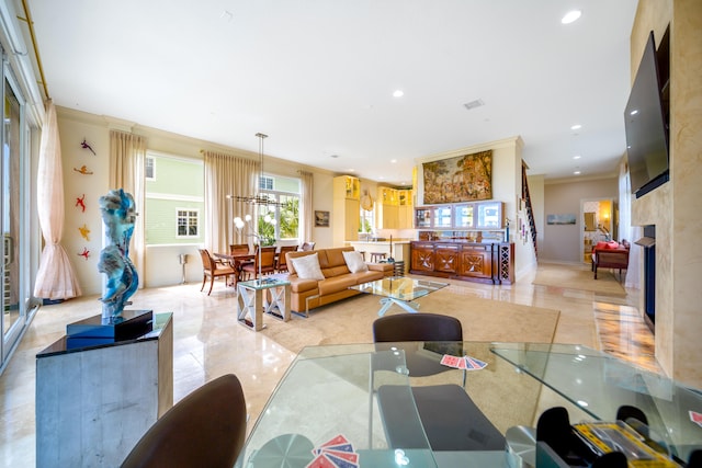 tiled living room featuring a premium fireplace, crown molding, and a notable chandelier