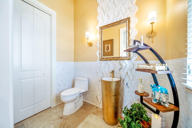 bathroom with toilet and tile walls