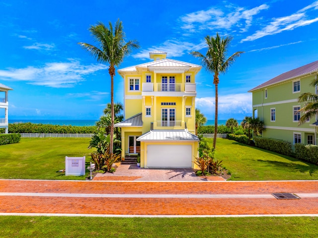 mediterranean / spanish house with a garage, a water view, a front yard, and a balcony