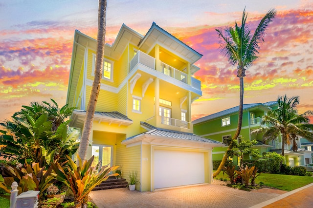 view of front of home featuring a garage and a balcony