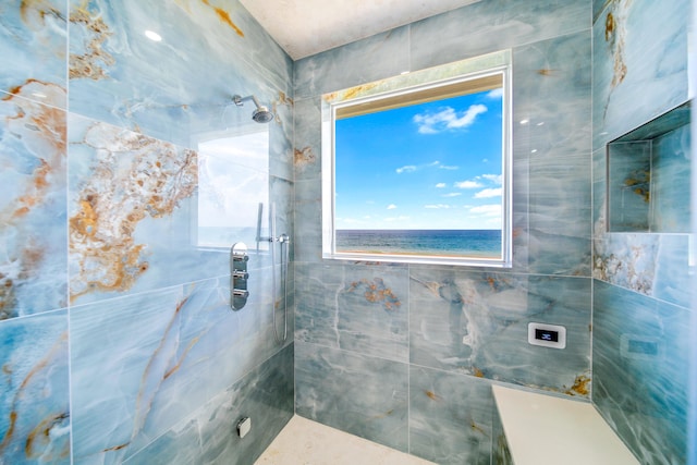 bathroom with tiled shower and a water view