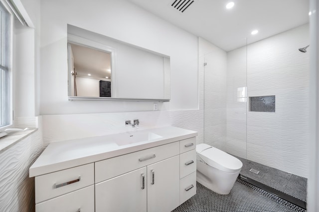 bathroom with tile walls, tile patterned floors, tiled shower, vanity, and toilet