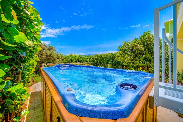 view of swimming pool with a hot tub