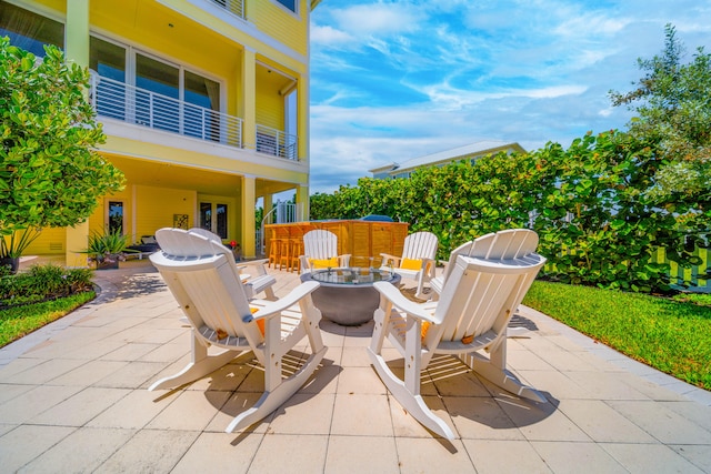 view of patio / terrace featuring a fire pit and a balcony