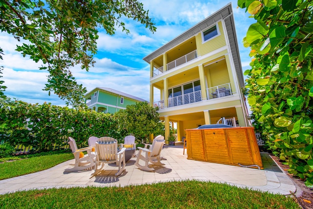 rear view of property featuring a balcony and a patio area