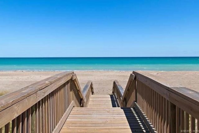 view of home's community with a beach view and a water view