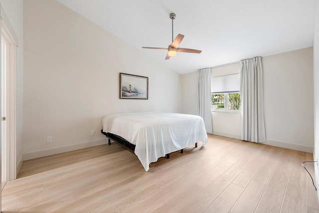 bedroom featuring ceiling fan, light hardwood / wood-style floors, and vaulted ceiling