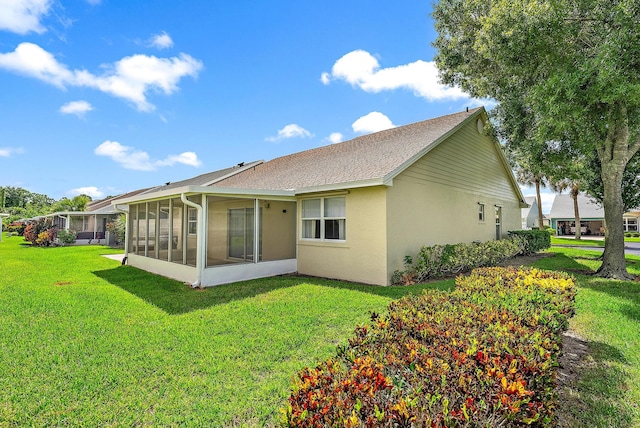 rear view of property with a sunroom and a yard