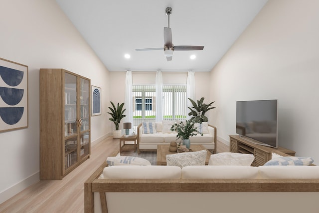 living room with ceiling fan, vaulted ceiling, and light hardwood / wood-style flooring