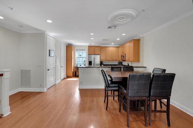 dining area featuring light wood-style floors, baseboards, visible vents, and crown molding