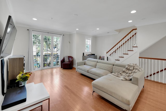 living room featuring light wood-style floors, stairs, crown molding, and recessed lighting