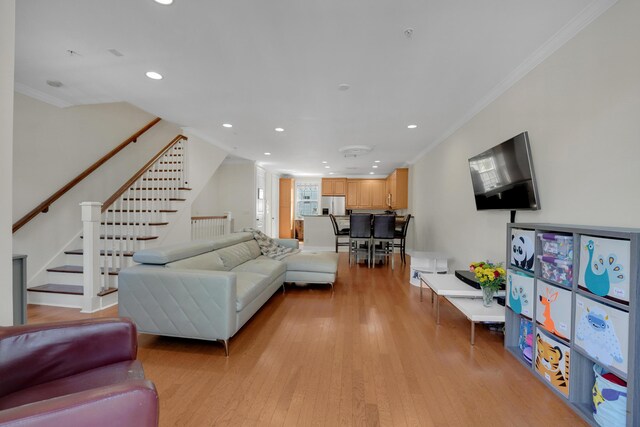 living room with light wood-type flooring, stairway, ornamental molding, and recessed lighting