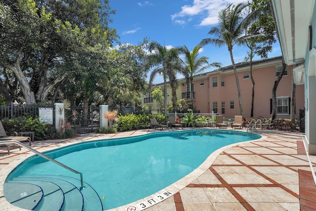 pool with a patio area and fence