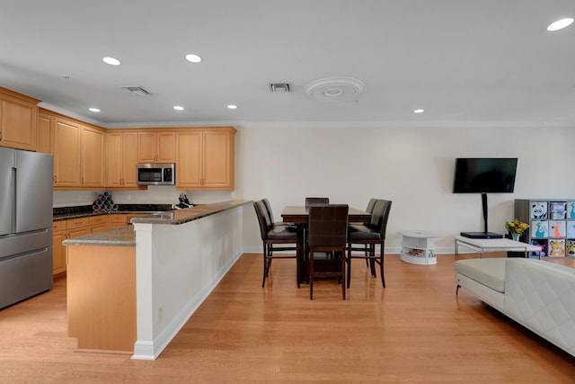 kitchen featuring visible vents, light brown cabinetry, appliances with stainless steel finishes, open floor plan, and a peninsula