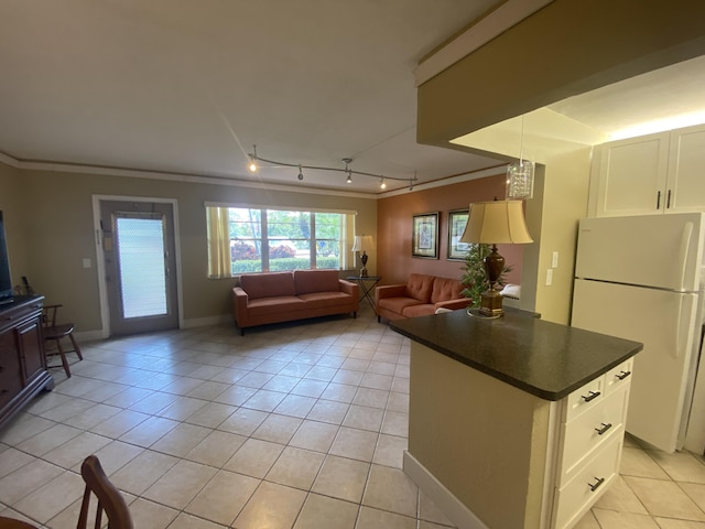 kitchen with white refrigerator, white cabinetry, and light tile patterned floors