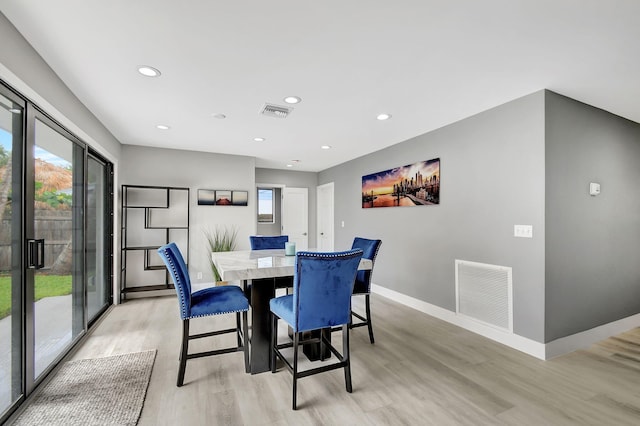 dining space featuring light wood finished floors, baseboards, visible vents, and recessed lighting