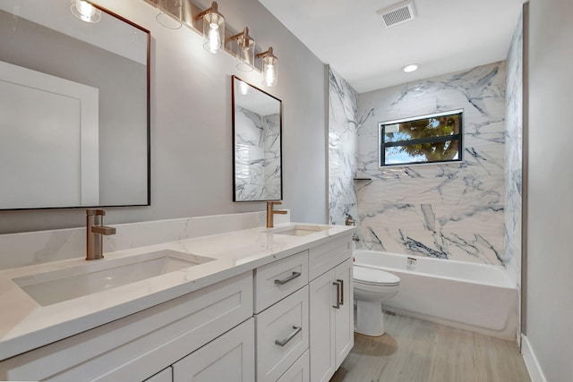 bathroom with visible vents, a sink, toilet, and double vanity