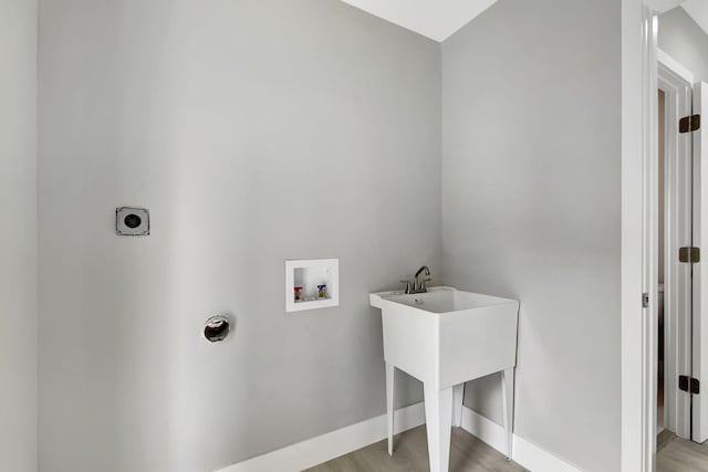 laundry area with laundry area, light wood finished floors, baseboards, hookup for a washing machine, and hookup for an electric dryer