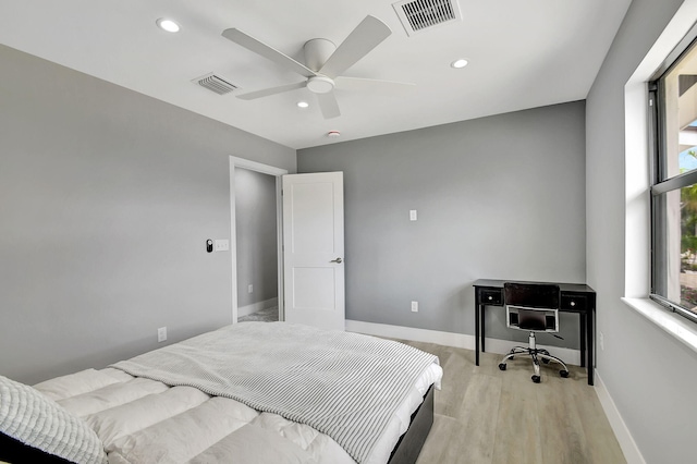 bedroom featuring light wood finished floors, visible vents, and baseboards