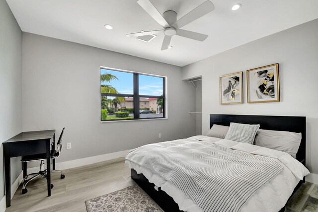 bedroom featuring light hardwood / wood-style flooring, ceiling fan, and a closet